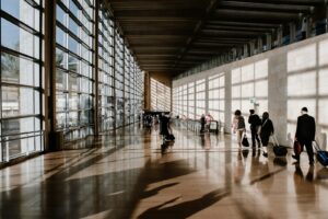 Voyageurs avec leurs valises traversant un terminal baigné de lumière